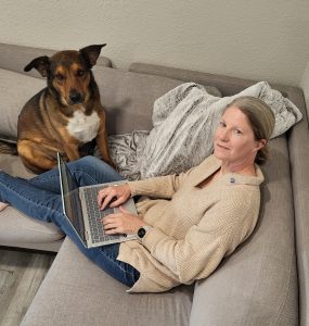 Realtor writing blog with a dog.